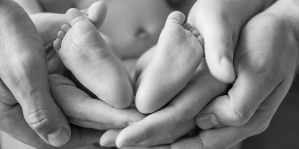 Voksne hænder og babyfødder